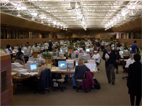 many people are in this large open room working on their laptops