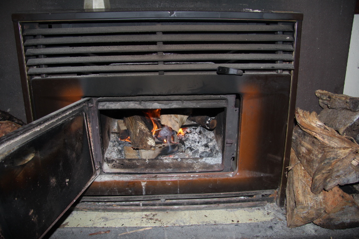 an old fashioned fireplace door with wood burning