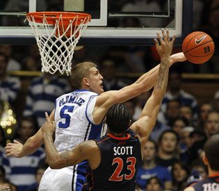 two players on opposing teams playing basketball against each other