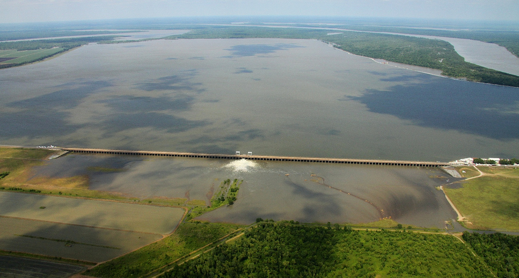 large flooded waterway between two farms in rural area