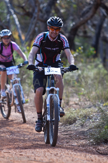 two men are riding their bikes in the dirt