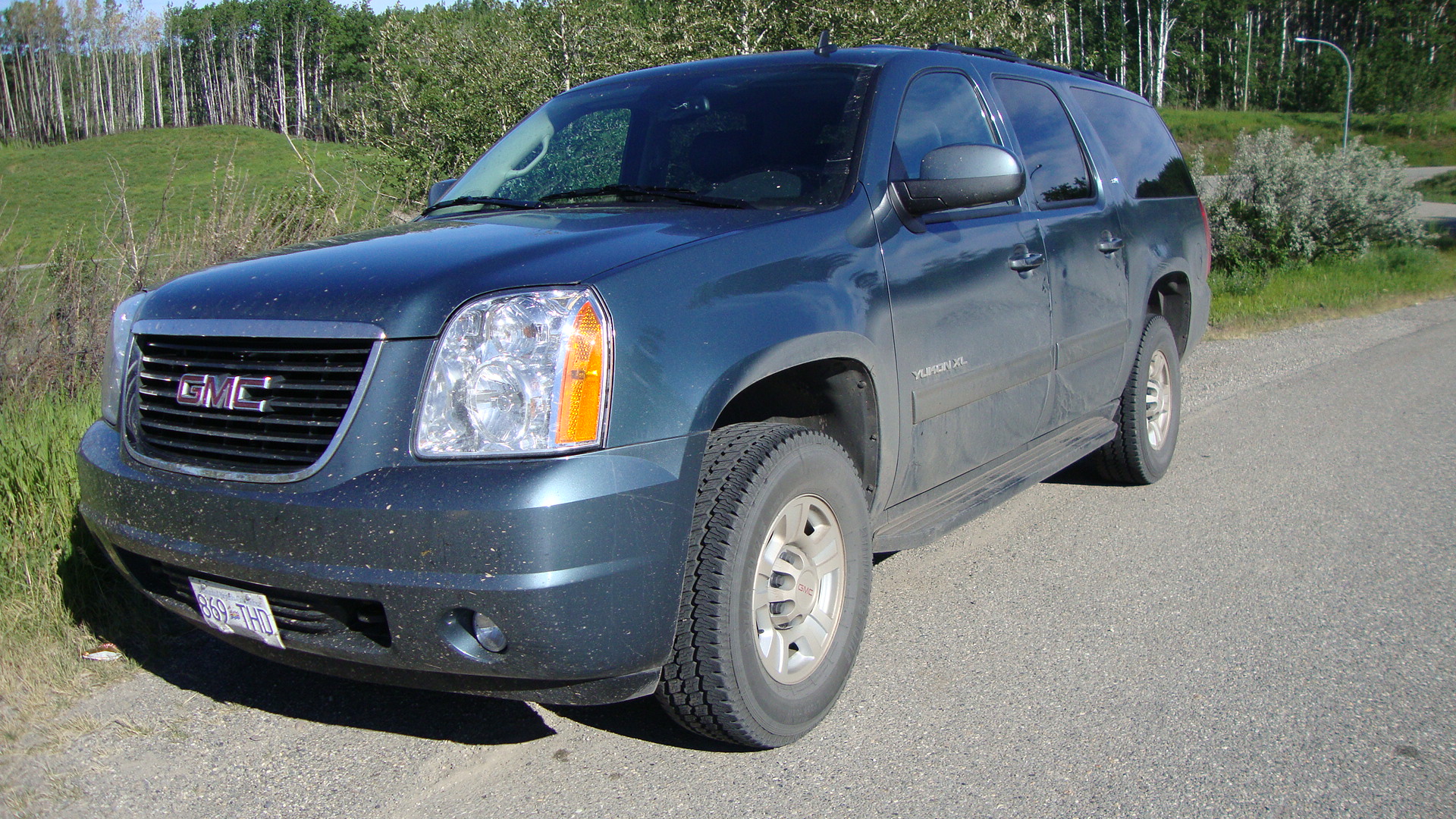 a gray suv parked on the side of a road