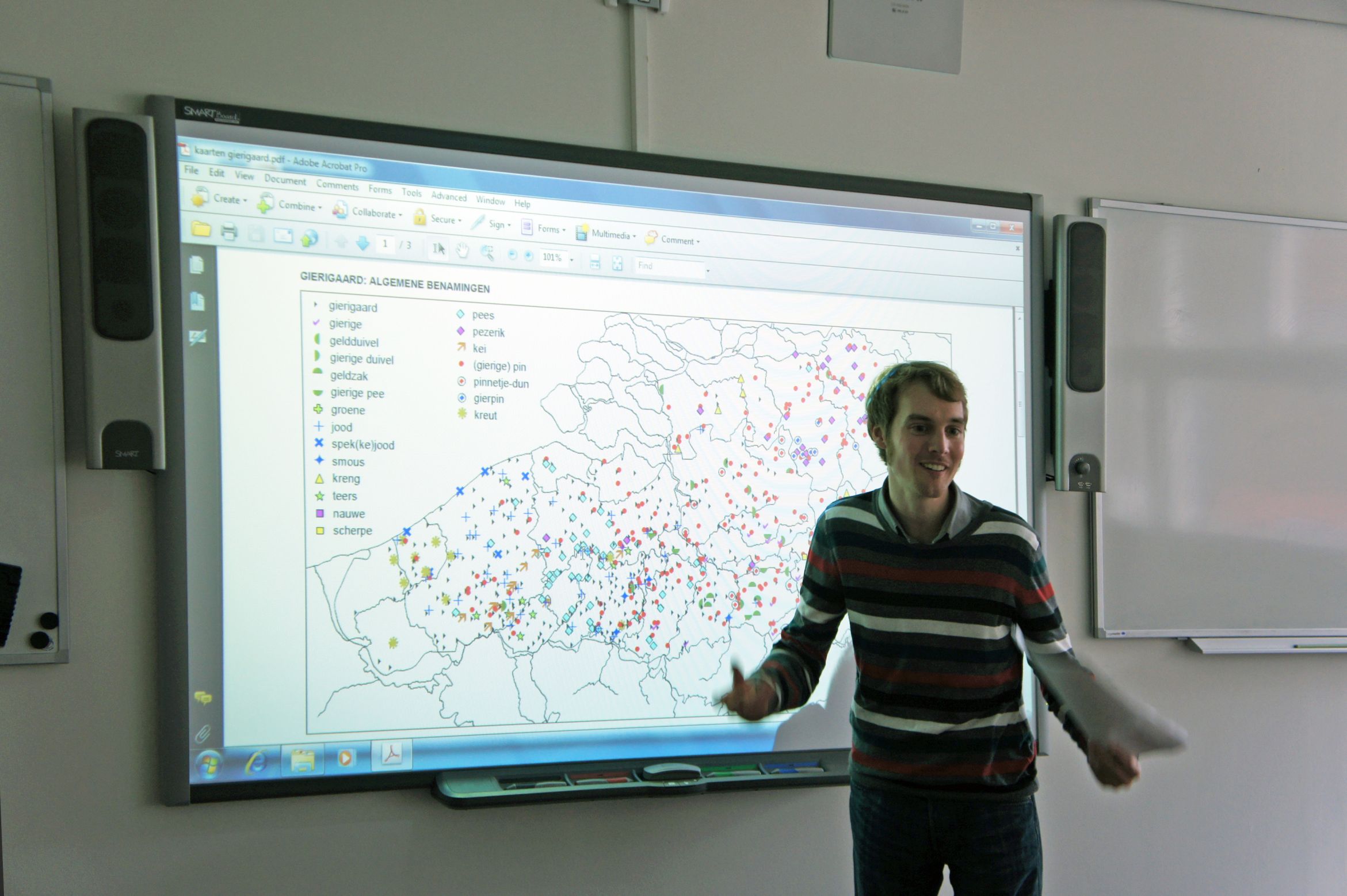 a young man standing in front of a big screen