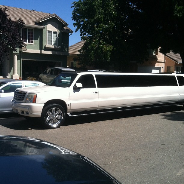 limousine with roof open parked in front of house