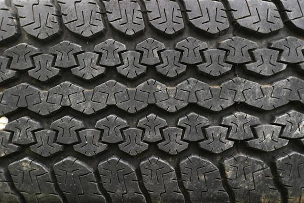 closeup po of a black tire with a rough tread pattern