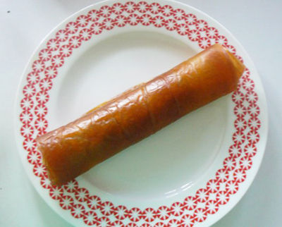 a sausage on a plate next to a fork and utensil