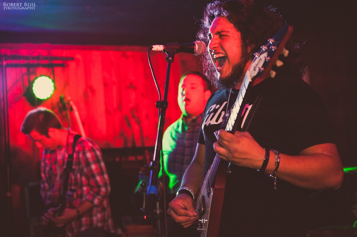 two people playing music on a stage with some microphones