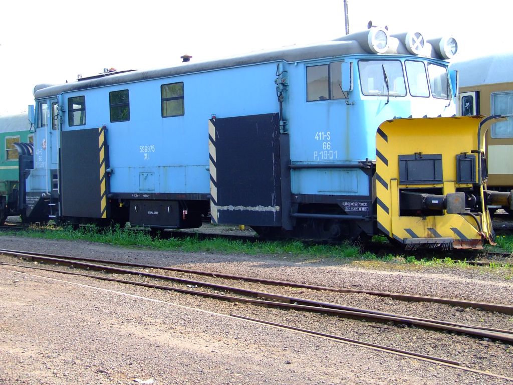 a blue train sitting on some tracks near other trains