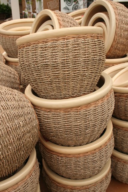 wicker baskets sitting on display in front of a brick wall