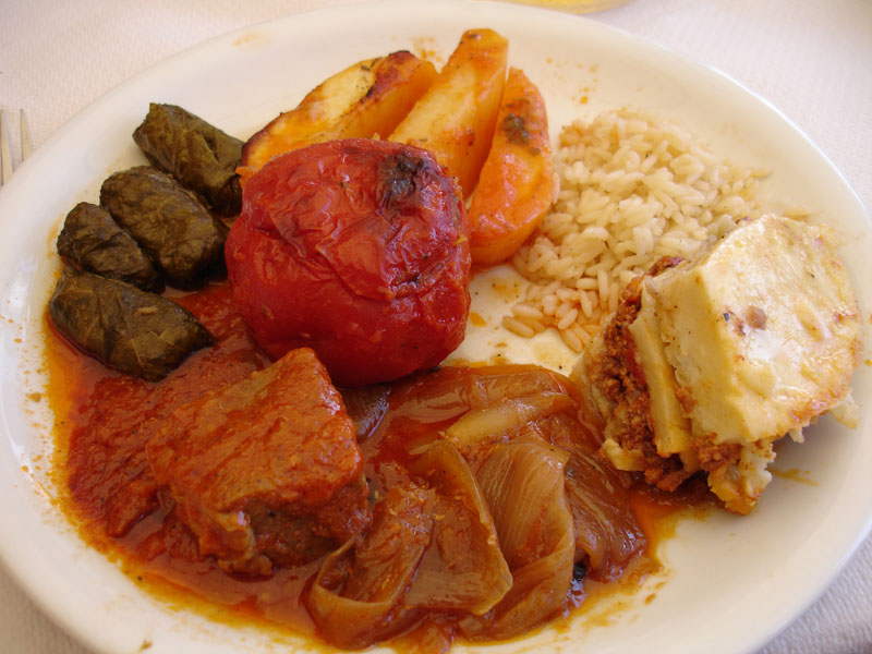 a plate with meat, rice and vegetables is shown