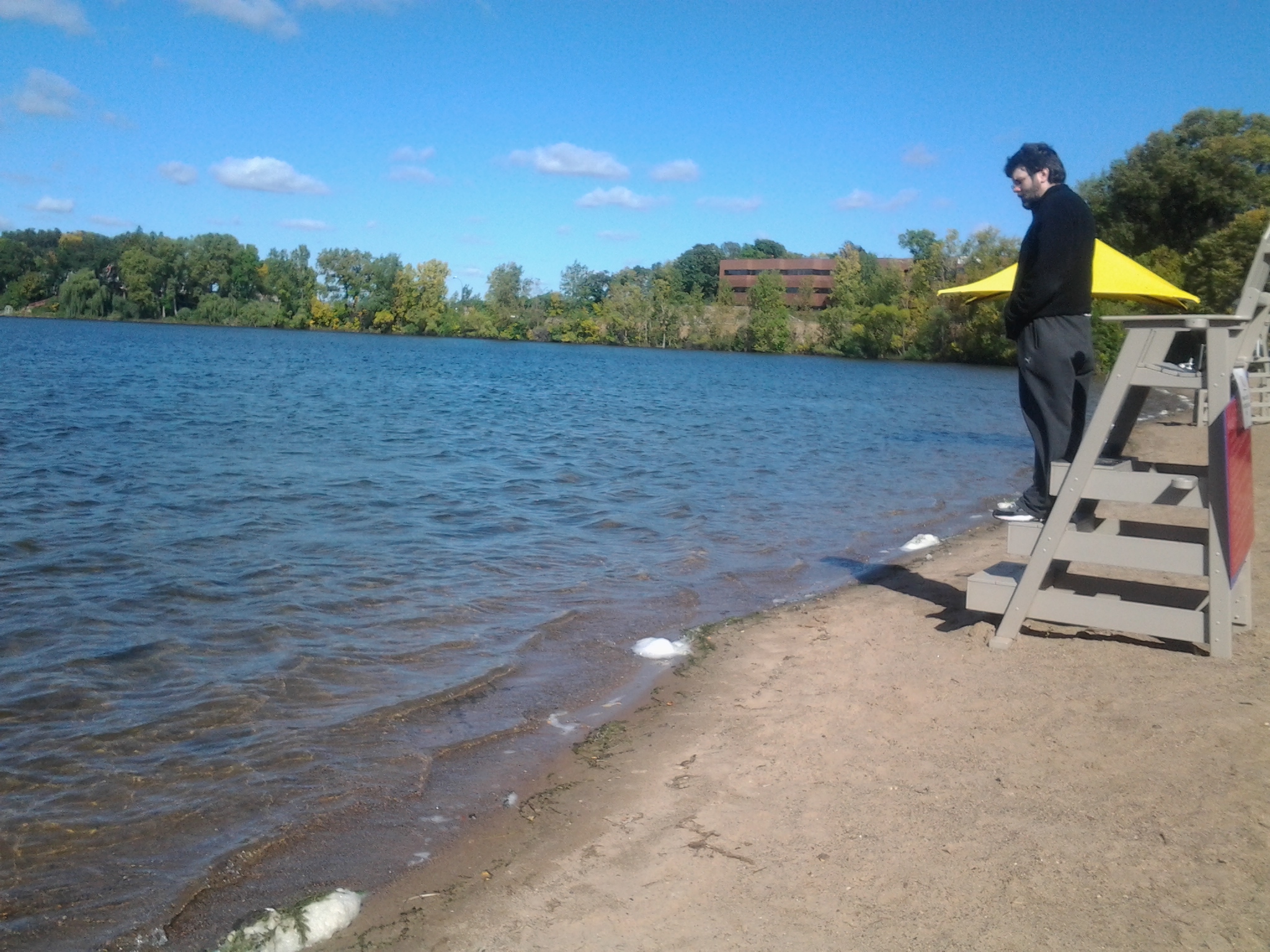 the man is standing on the edge of a lake while holding his board