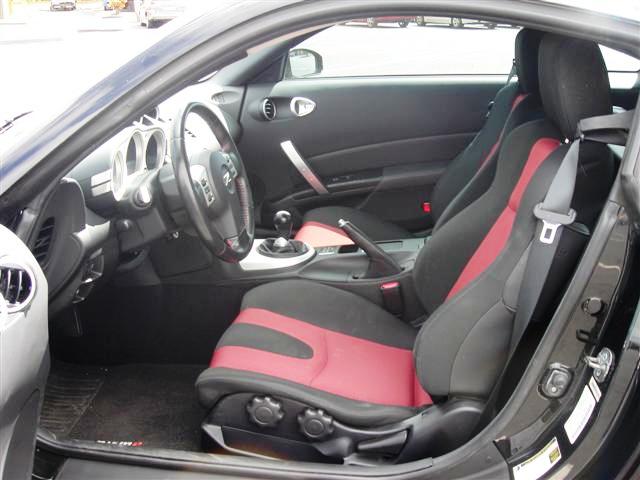 a car with black leather and red stitching and a front seat up