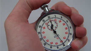 a person holding a small clock in their hand