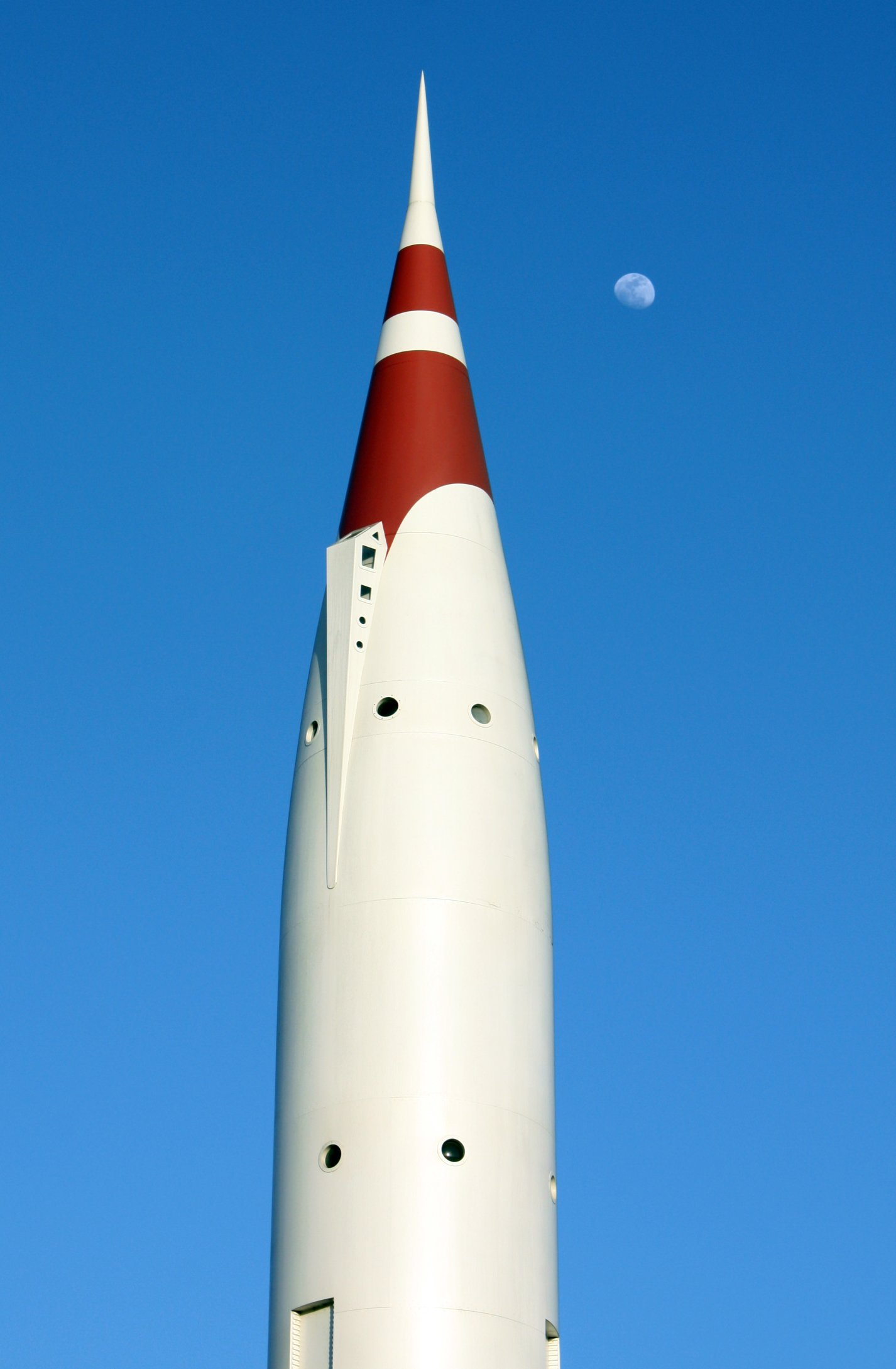 a large white and red jet flying through a blue sky