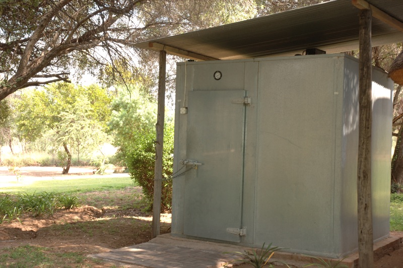 a small outdoor toilet on the side of the road