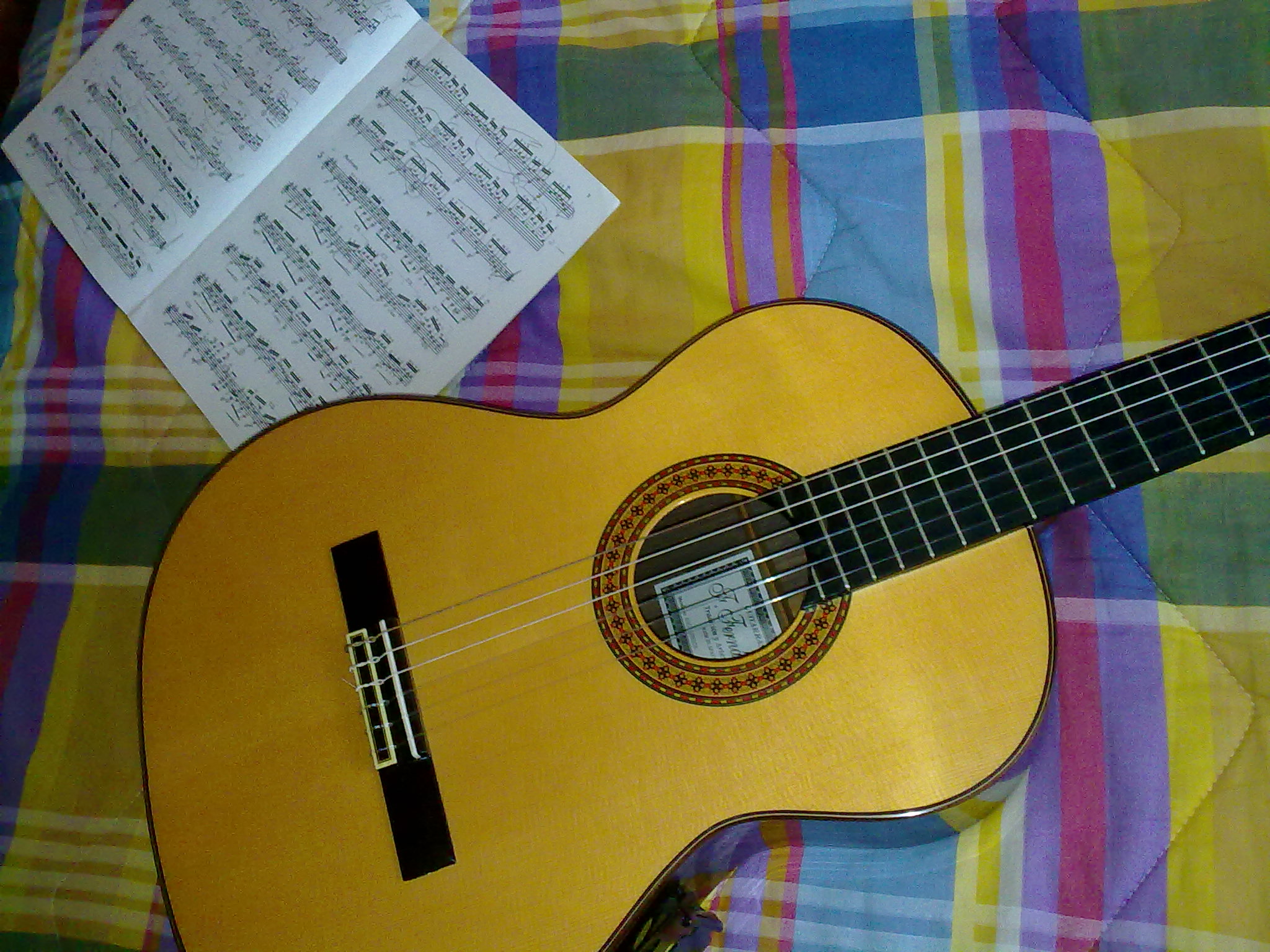 an acoustic guitar lying next to sheet music