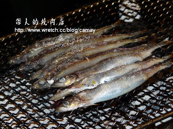 fresh fish being cooked on the grill with other fish