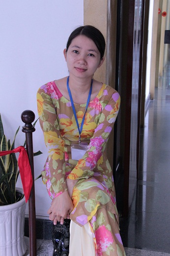 a young asian woman sits by herself on the ground