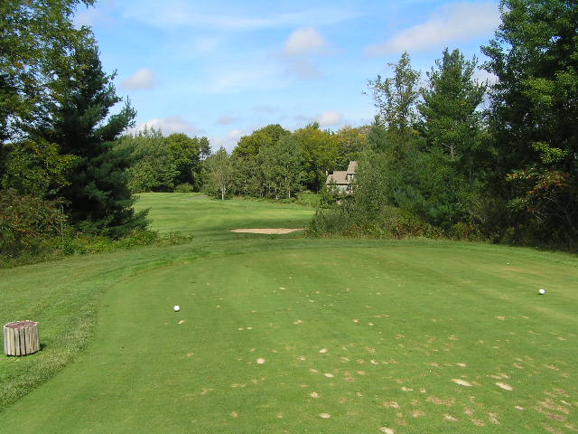 an empty hole at a golf course with a white tee
