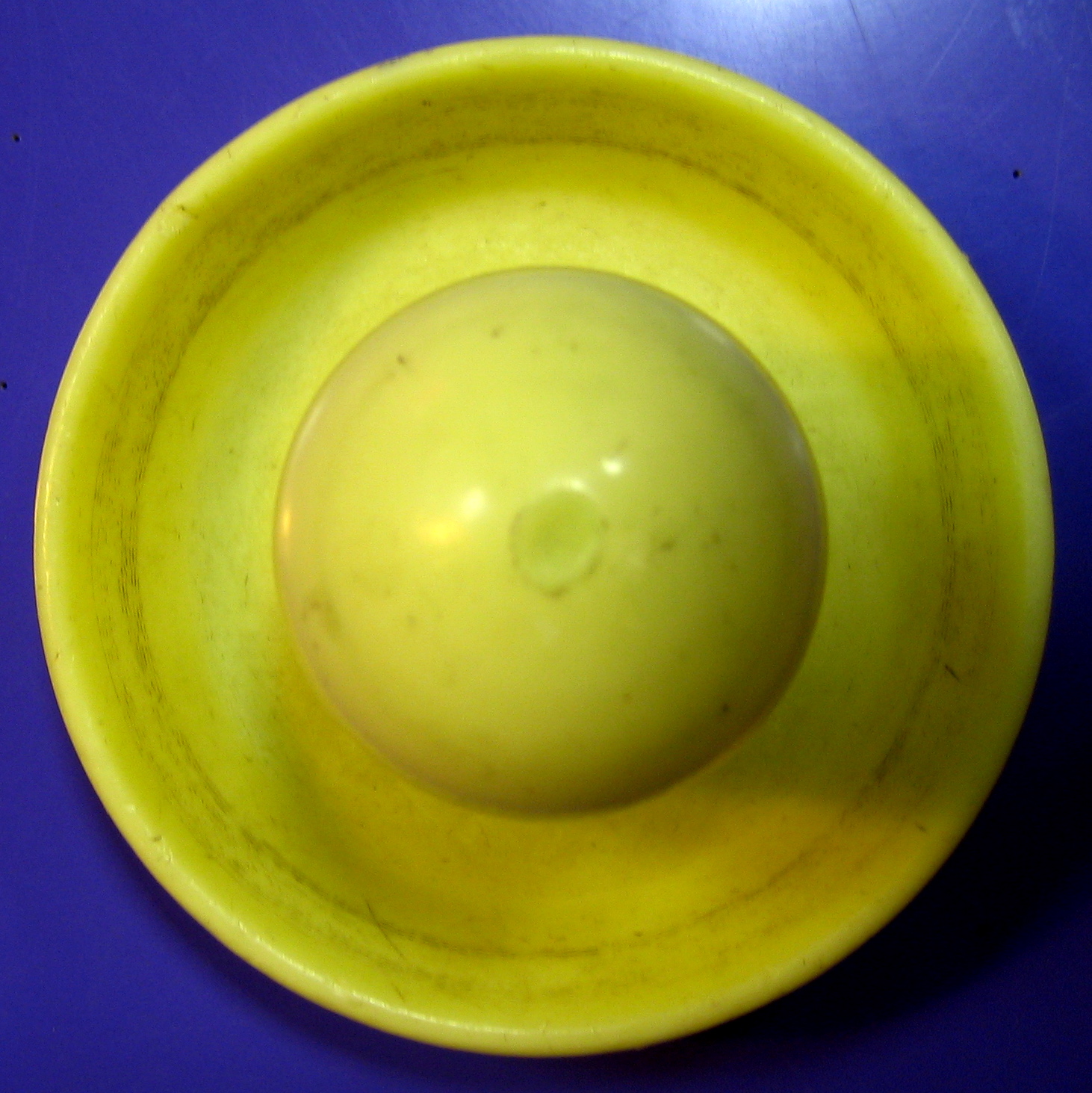 an empty yellow bowl on top of a blue table