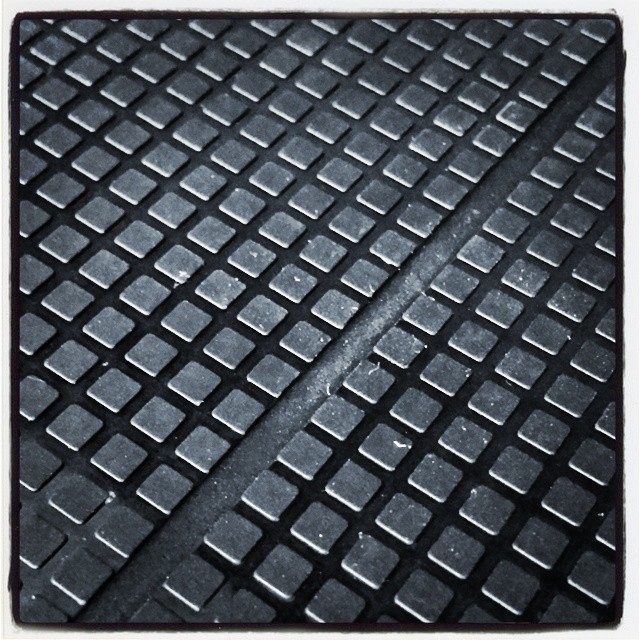 a tile floor is shown with square shaped black squares