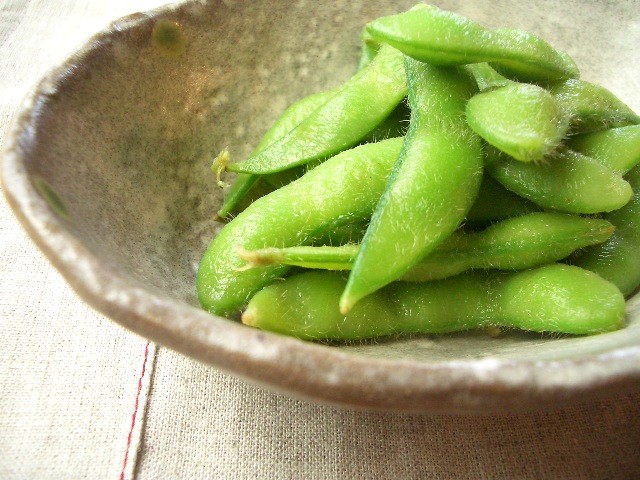 small green peas sit in a bowl on a table