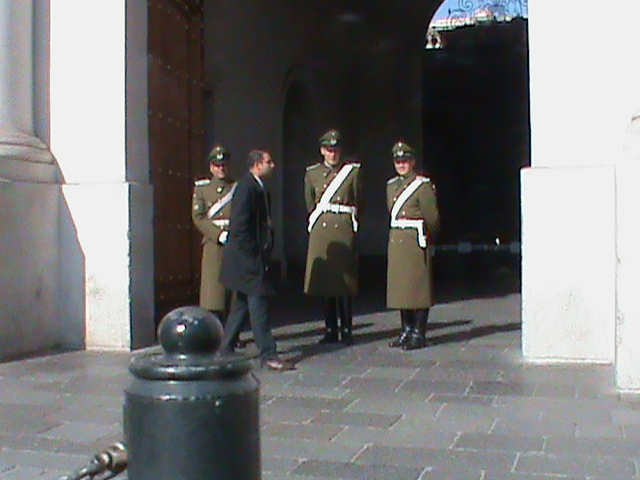 several men standing outside in uniforms on a sidewalk