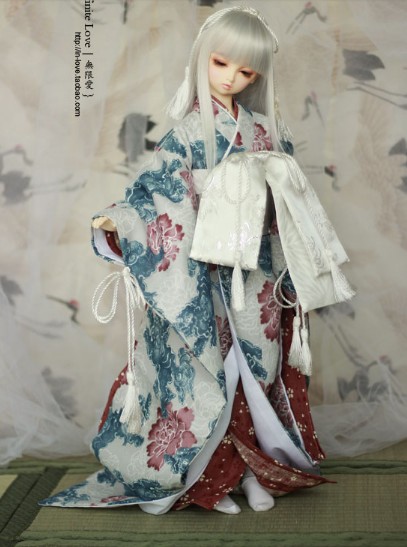 a doll with white hair is posed next to a wall