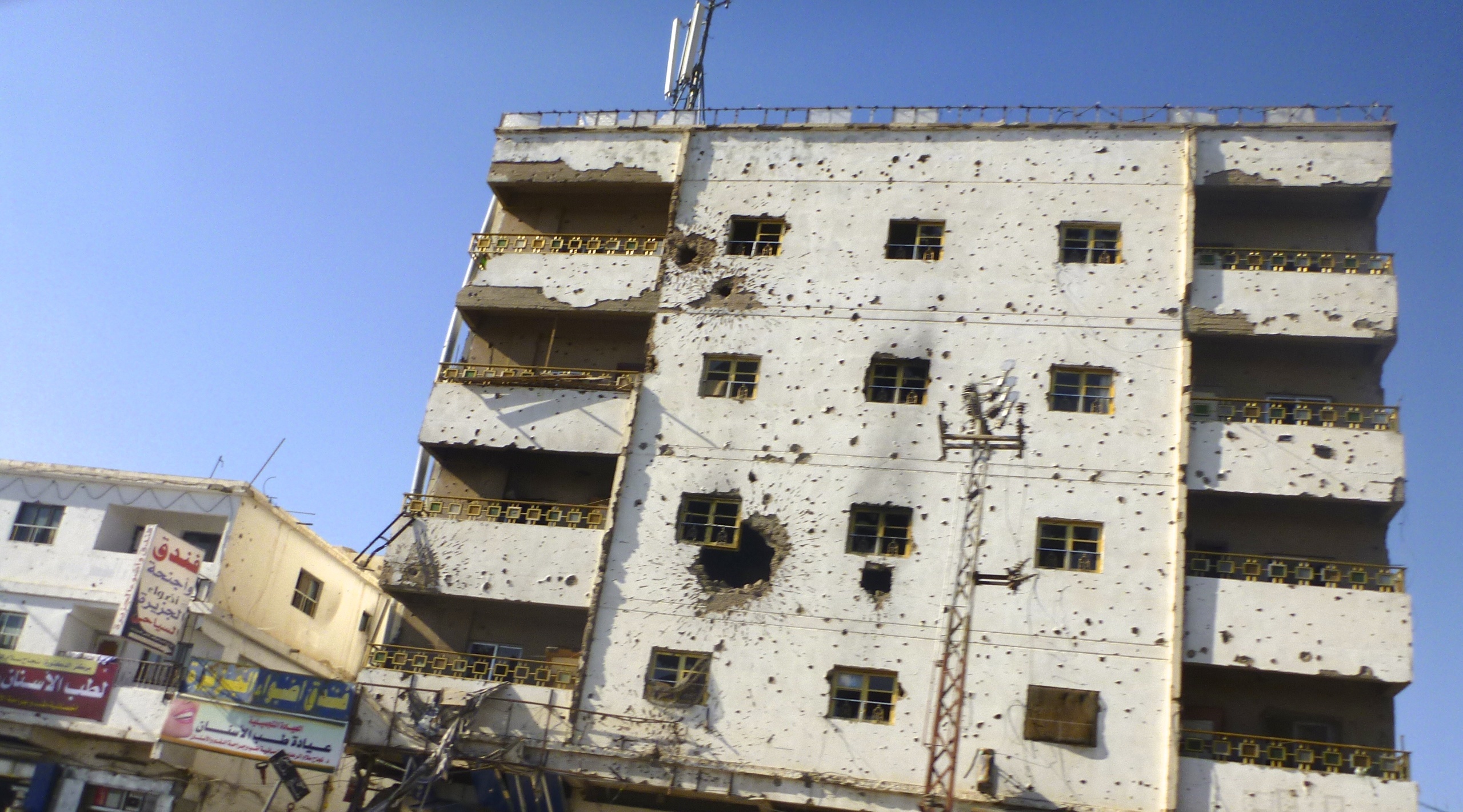 the side of a high rise apartment building with broken windows