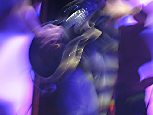 blurred po of a guy playing a guitar