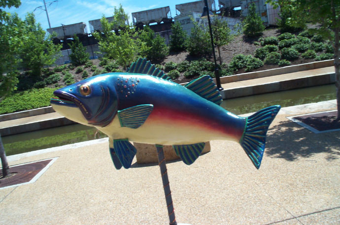 a fish sculpture is on display at a park