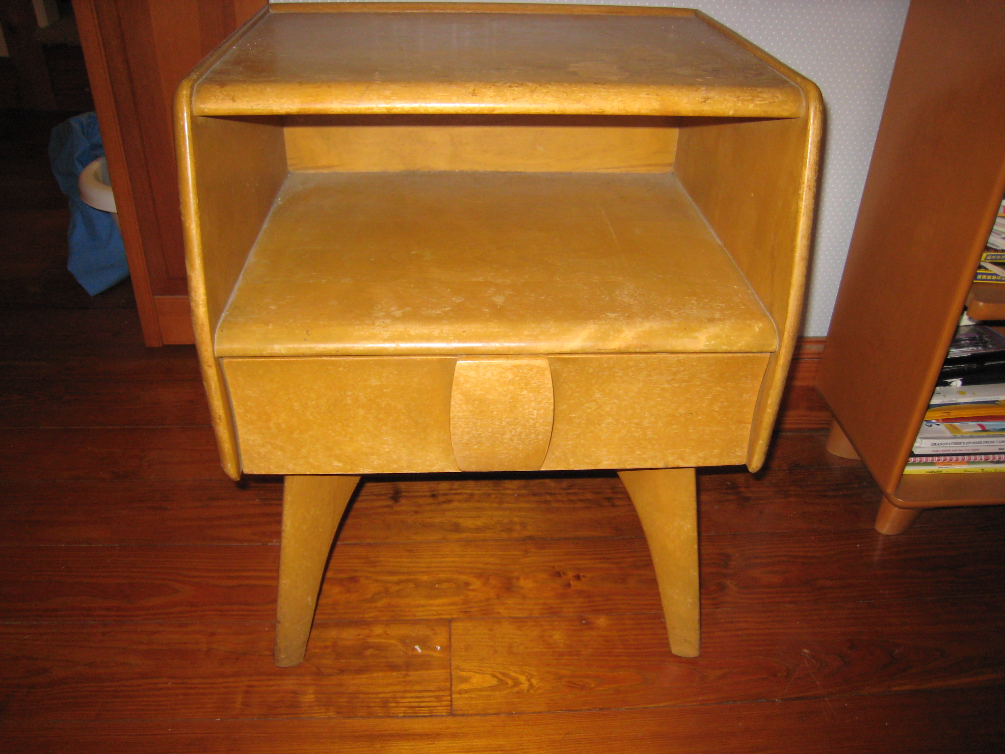 a golden nightstand with a drawer on it
