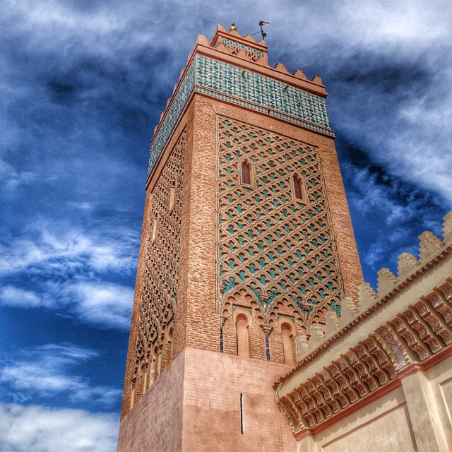 a very tall brown tower with a cross at the top