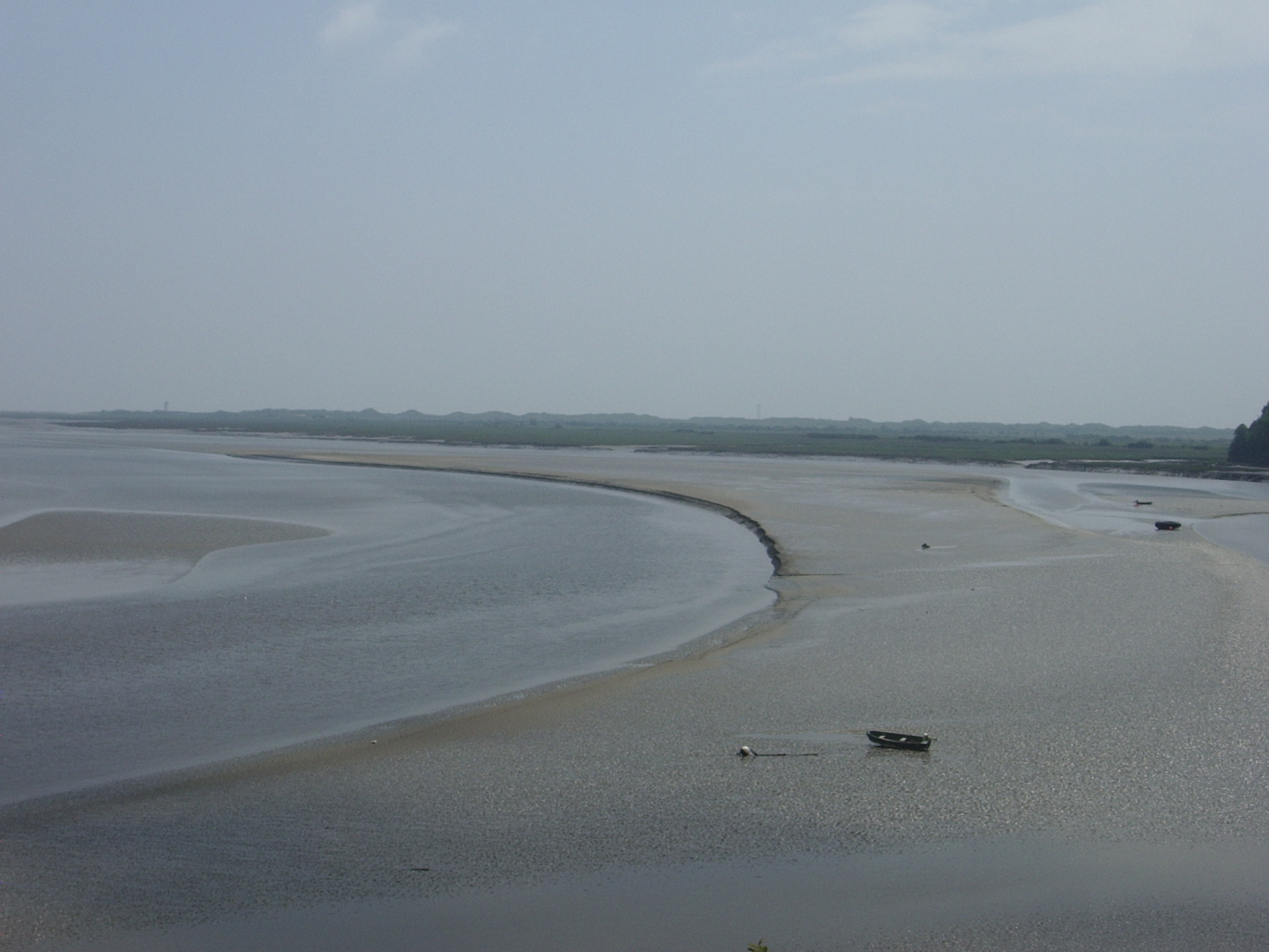 an empty river sits on a beach with several sand banks