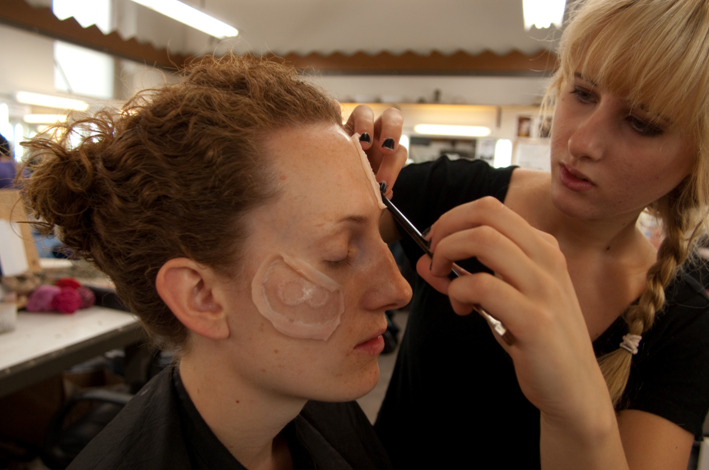 a woman is putting on a face mask in a beauty salon