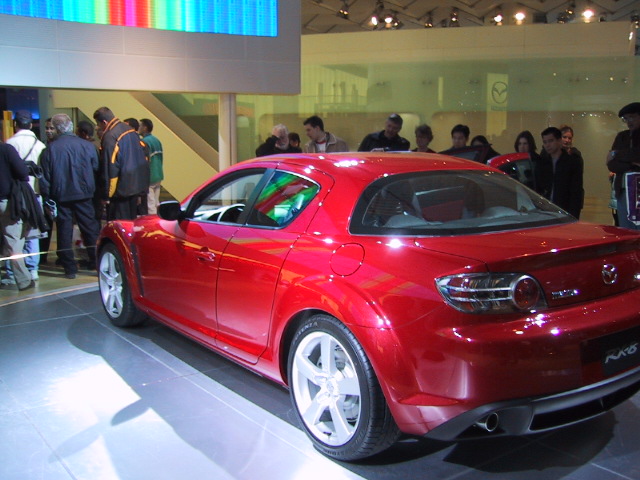 a red car is displayed at an auto show