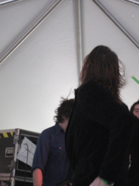 two people are standing underneath a white tent