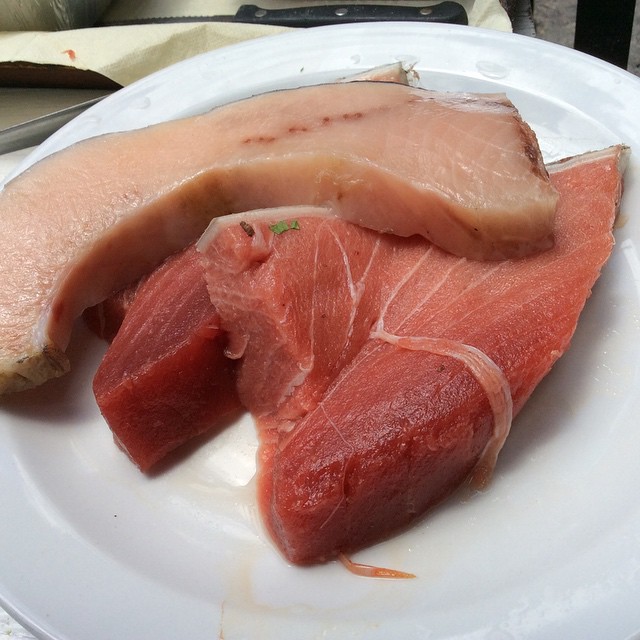 the raw fish is cut in half and sitting on the plate