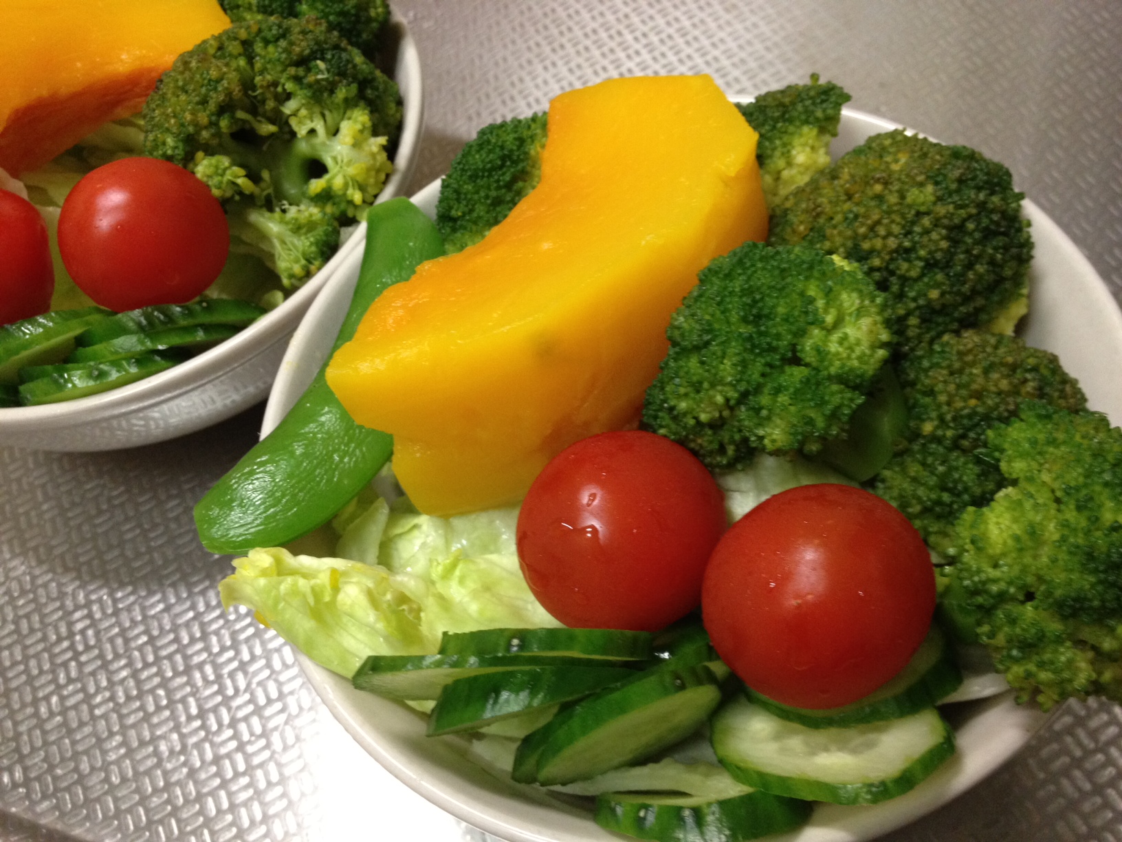 a white bowl with some green and red vegetables