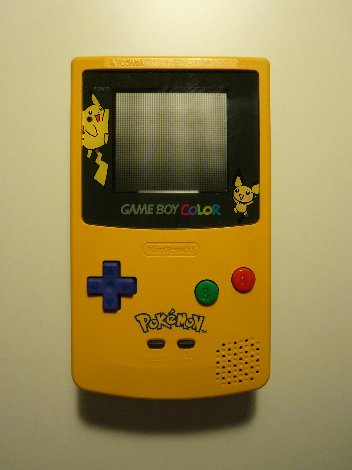 a yellow and black gameboy next to a wall