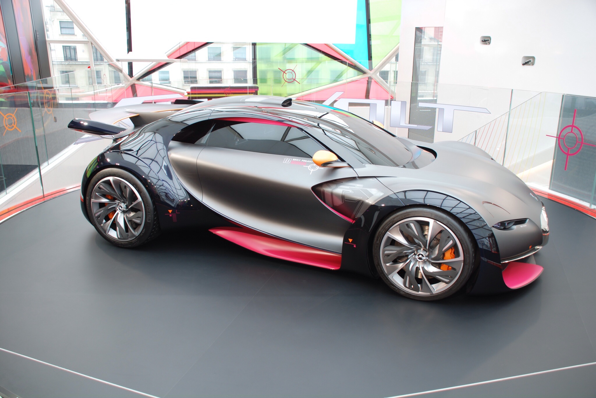 the car has pink interior and is parked on a large display