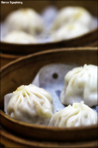 dumplings in a bamboo bowl with a small spoon