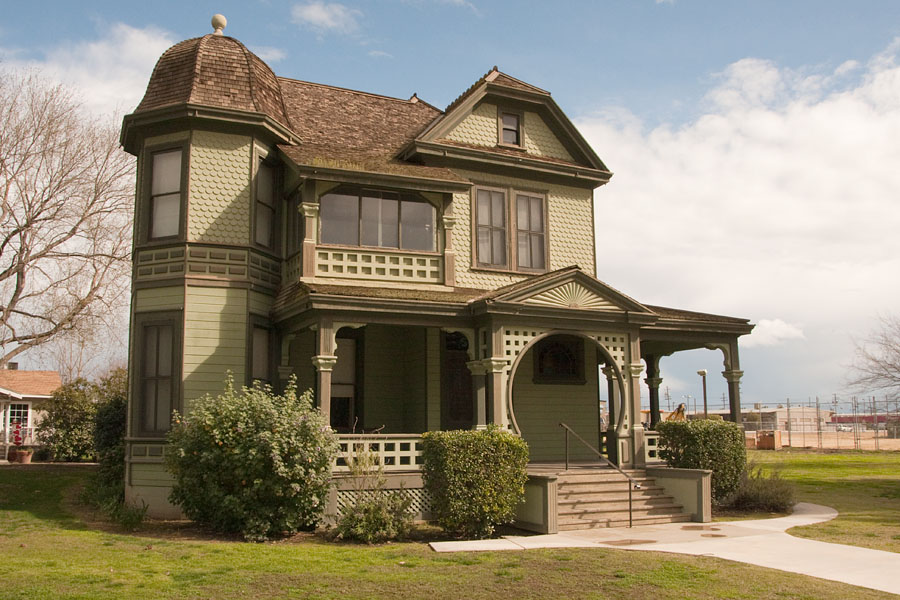 a small, old house that is in the middle of a green lawn