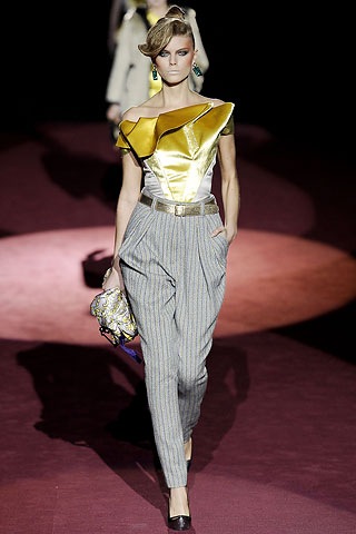a woman on the runway holding onto a purse