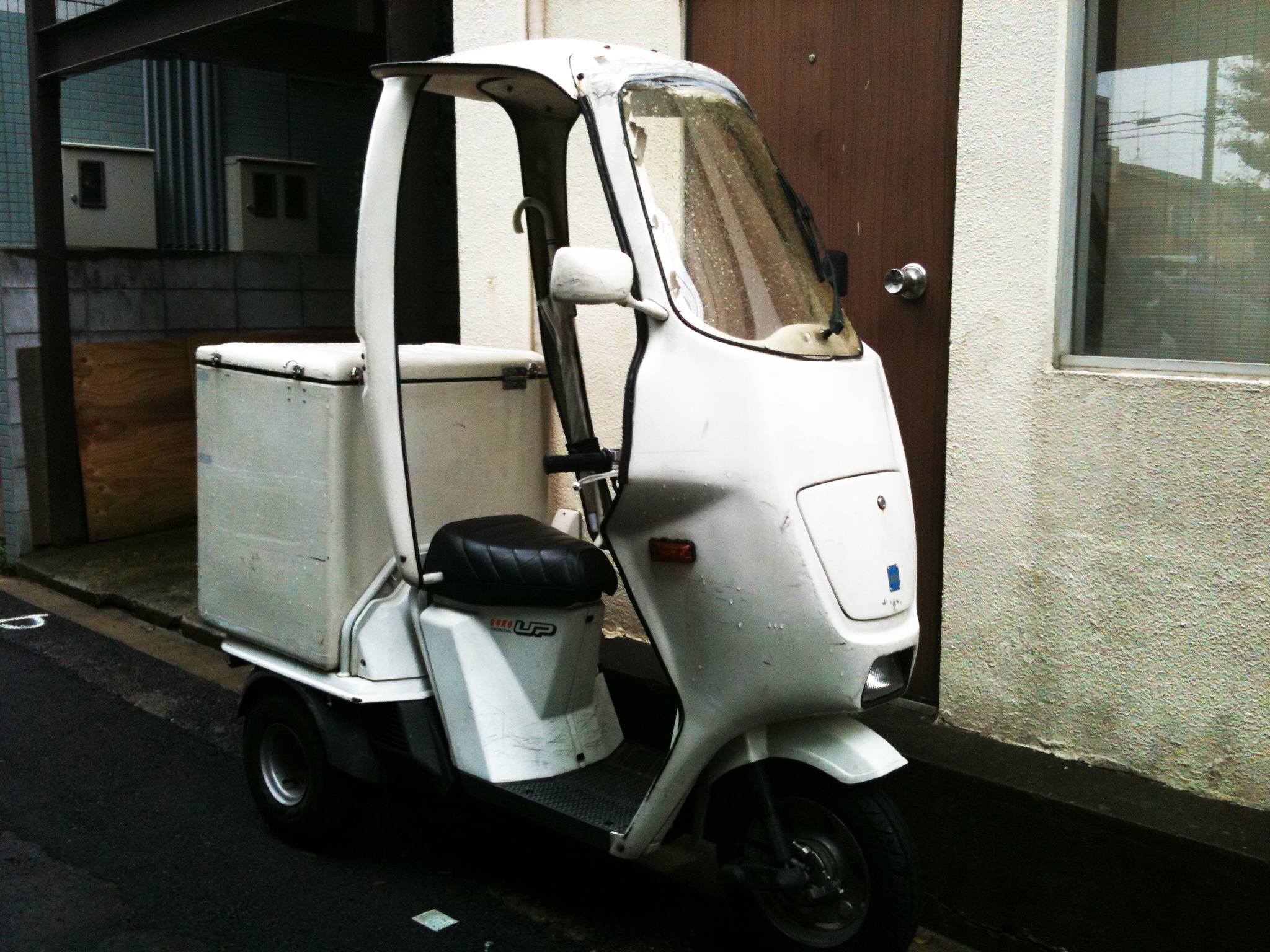 a motor scooter parked outside a small apartment