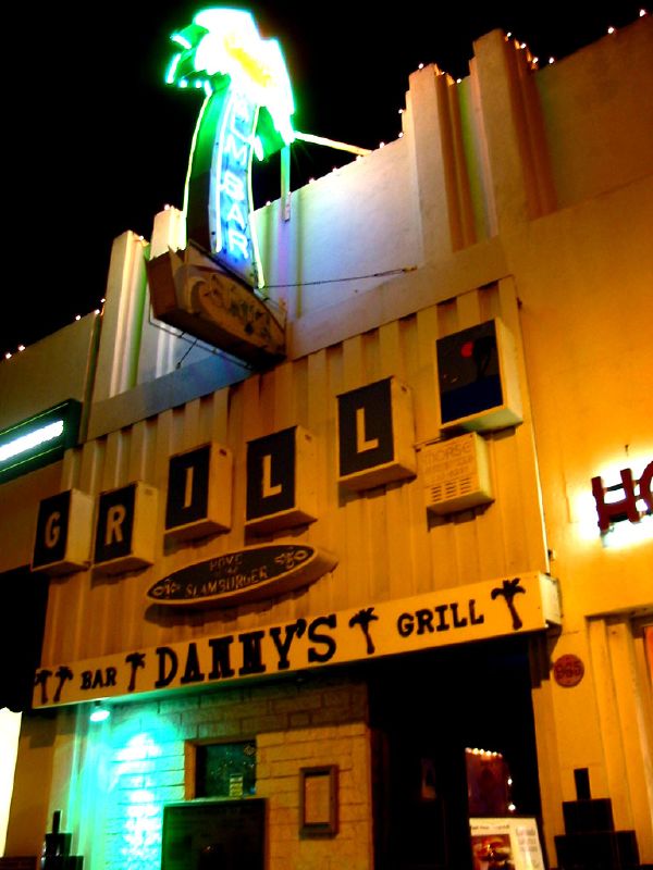 a small building with some signs lit up on it