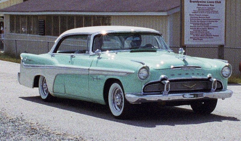 an old car in front of a church