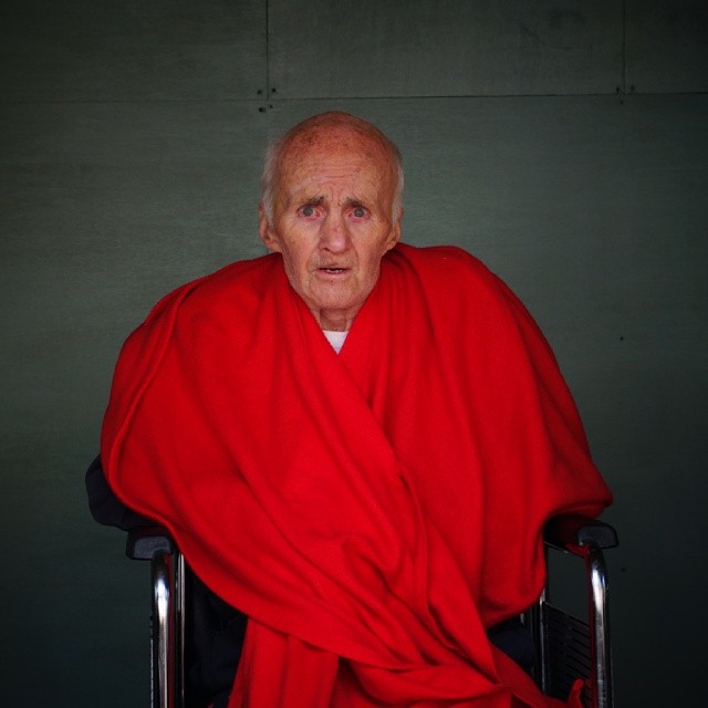 old man in red and a red chair with his arms wrapped around him