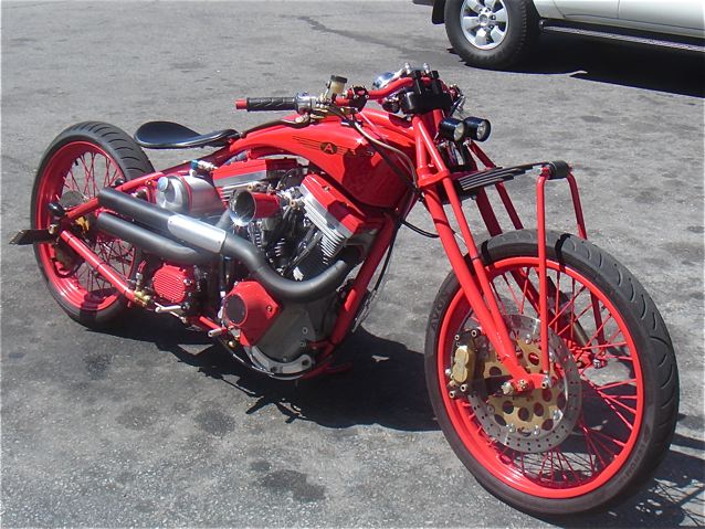 a red motorcycle is parked in an empty parking lot