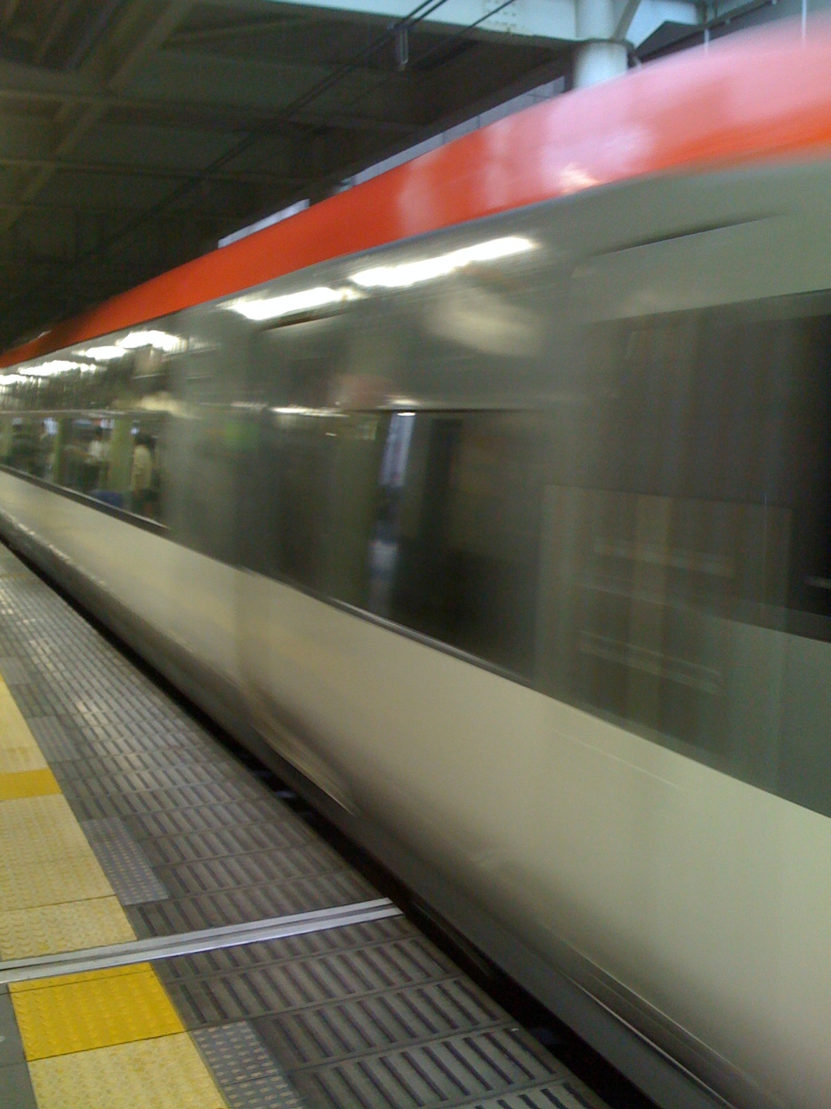 a white and gray train driving past a subway station